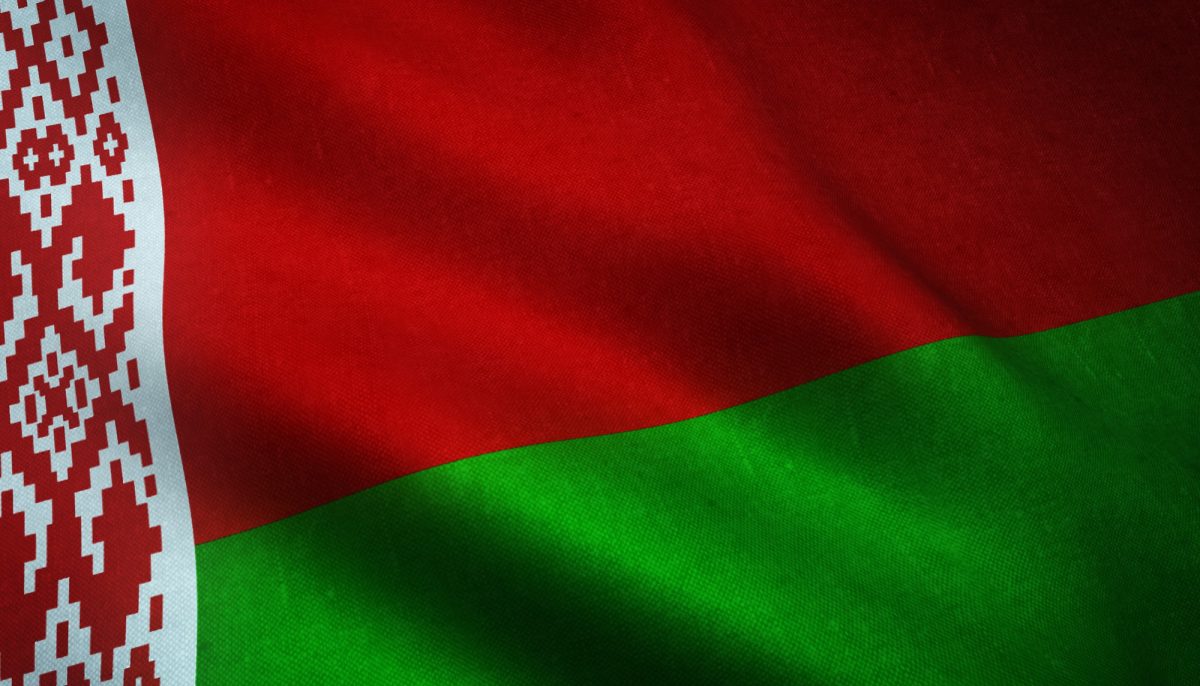 Close-up of the Belarusian flag with red and green colors and traditional pattern.