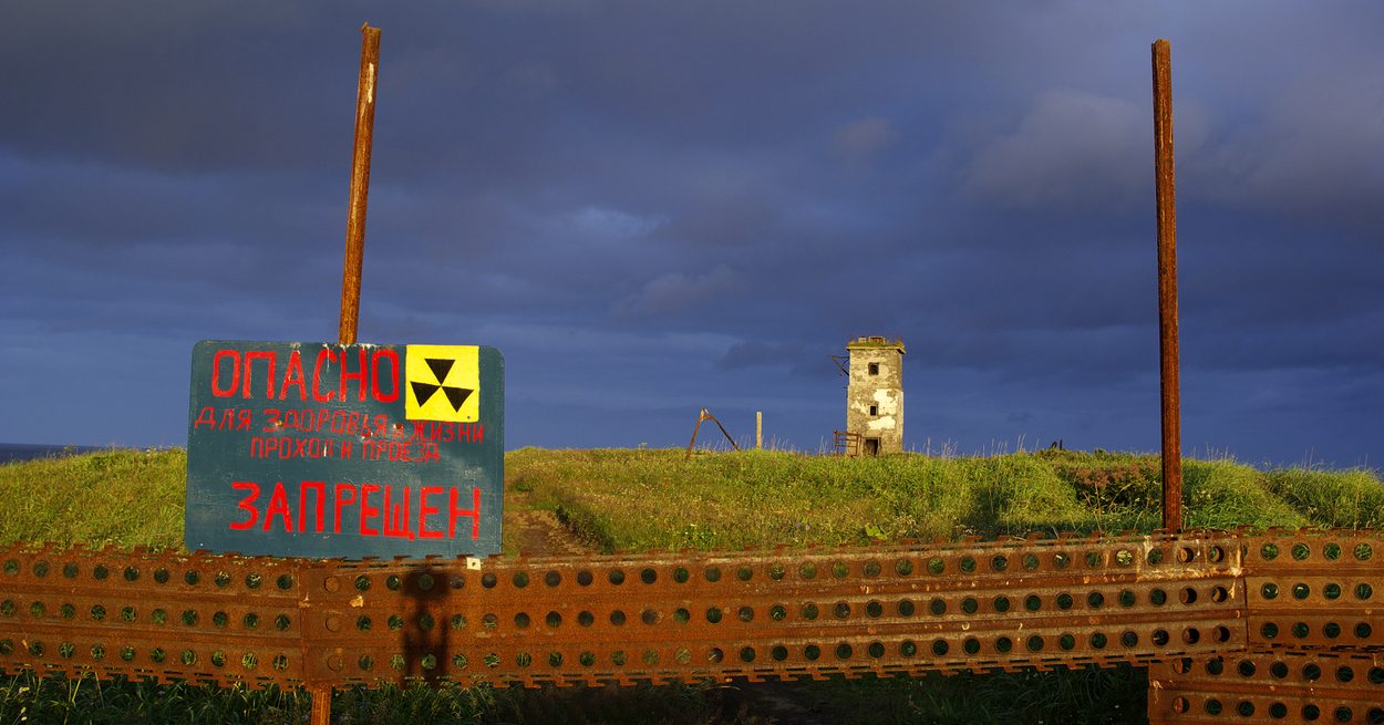 Warning sign with radiation symbol marking a nuclear hazard zone.