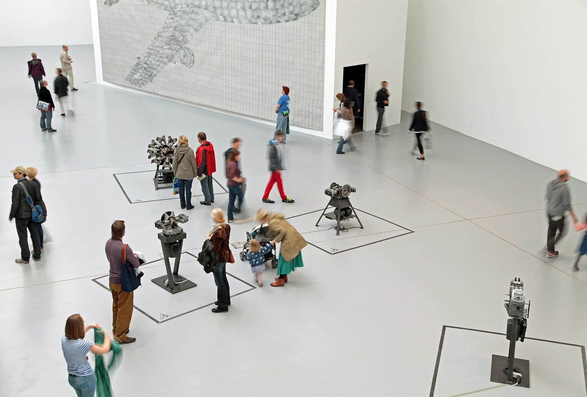Ihmiset katsovat veistoksia modernissa museorakennuksessa