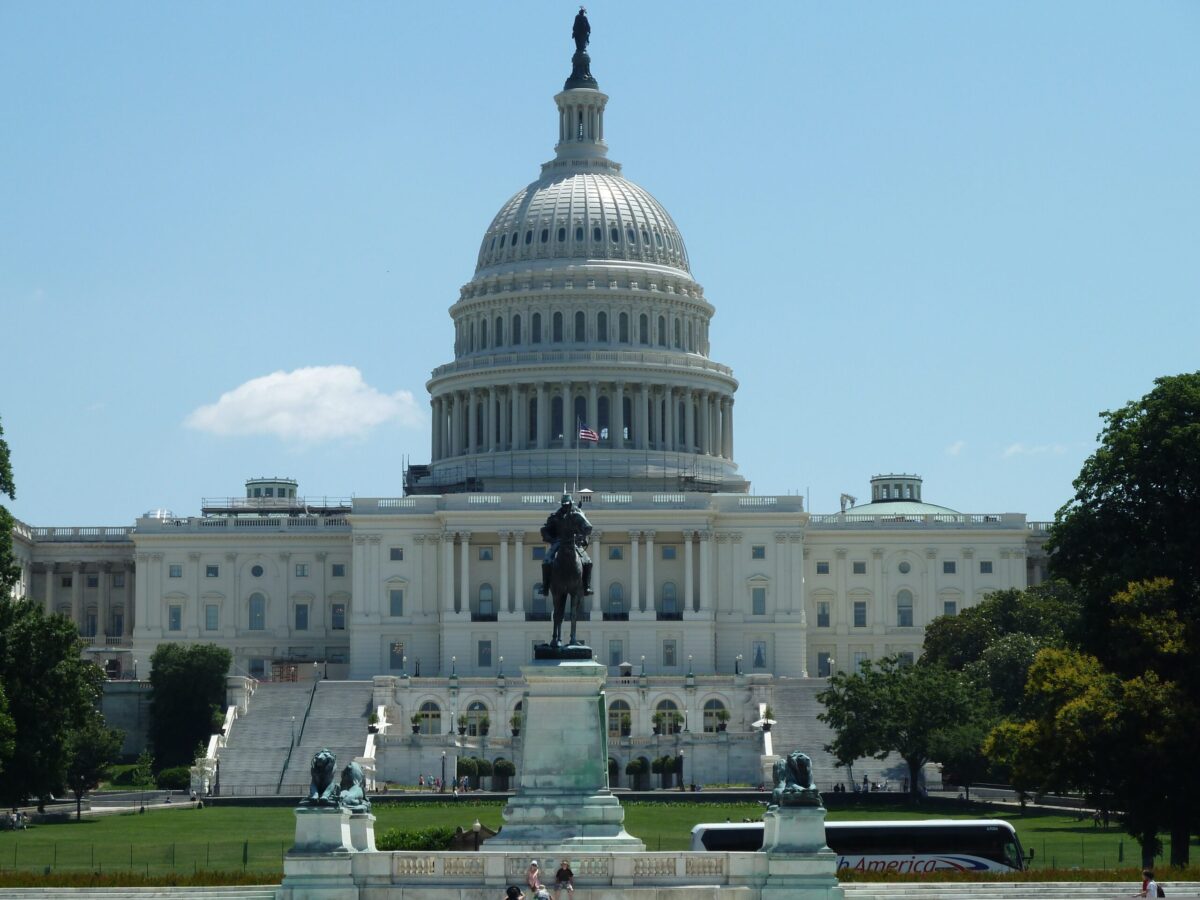 United States Capitol in Washington, DC, with iconic dome under clear blue sky.